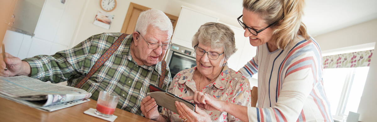 Elderly couple reading material with daughter