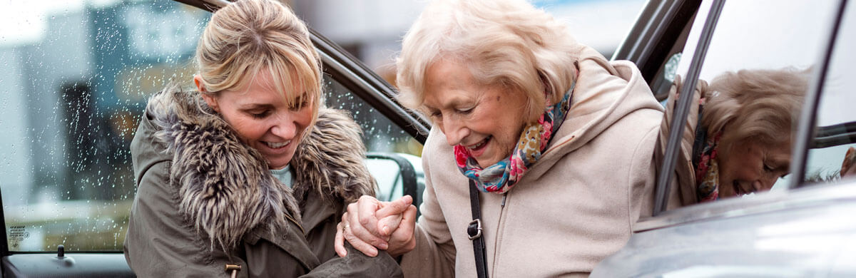 caregiver assisting client out of a car