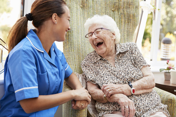 Caregiver laughing with senior client
